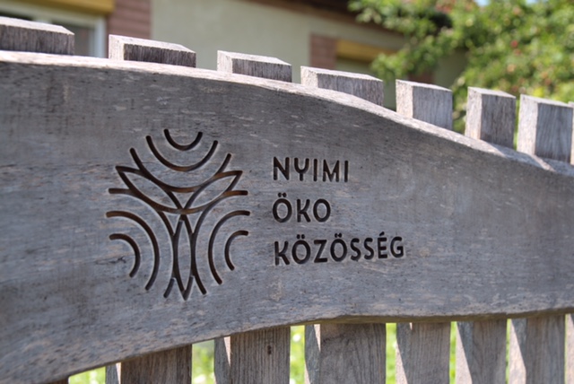 Kép: A Nyimi Öko Közösség fába vésett logója